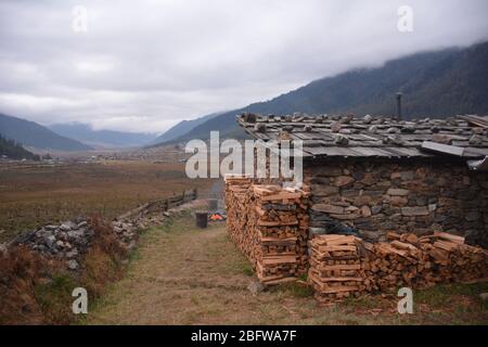 Un bagno tradizionale in pietra calda completo di un fuoco da campeggio e vista della valle di Phobjika, Bhutan. Foto Stock