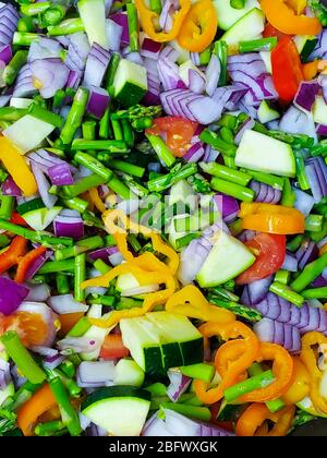 Un mix di verdure fresche crude, tra cui asparagi, cipolla viola, pomodoro, peperone e zucchine. Foto Stock