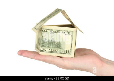 Mano che tiene una casa fatta di dollari su sfondo bianco primo piano Foto Stock