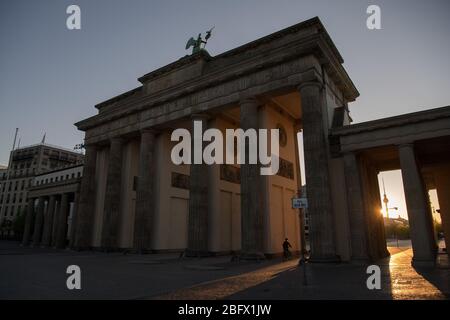 Berlino, Germania. 20 aprile 2020. Il sole sorge alla porta di Brandeburgo. Credit: Jörg Carstensen/dpa/Alamy Live News Foto Stock