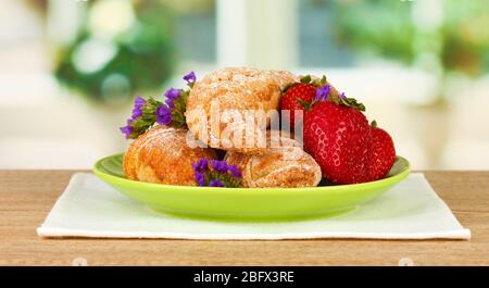 Bagel freschi con fragola nel piatto sul tavolo Foto Stock