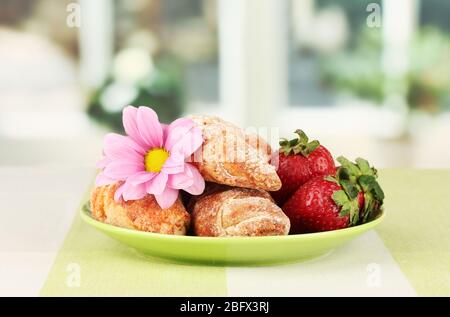 Bagel freschi con fragola nel piatto sul tavolo Foto Stock