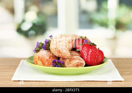 Bagel freschi con fragola nel piatto sul tavolo Foto Stock