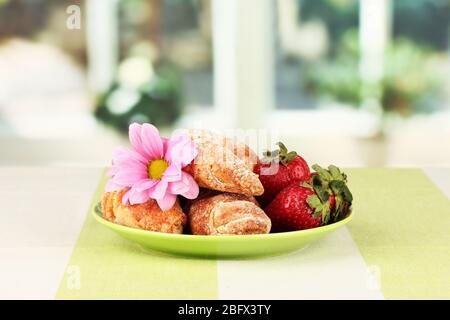 Bagel freschi con fragola nel piatto sul tavolo Foto Stock