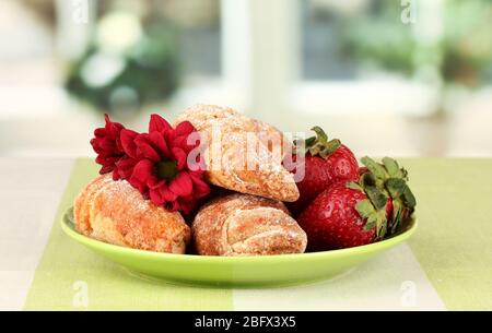 Bagel freschi con fragola nel piatto sul tavolo Foto Stock