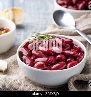 Fagioli rossi in scatola in una ciotola bianca su un tavolo Foto Stock