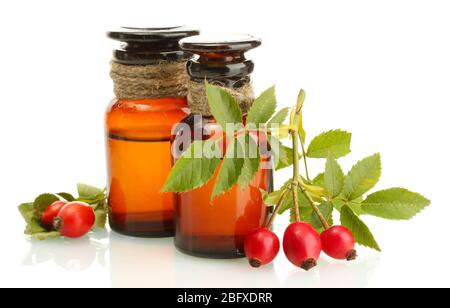 flaconi di medicina con rose dell'anca, isolati su bianco Foto Stock