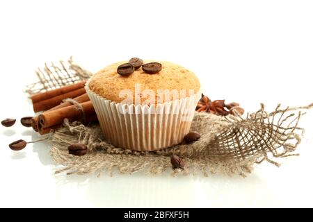 gustosa torta al muffin su burlap, spezie e semi di caffè, isolata su bianco Foto Stock