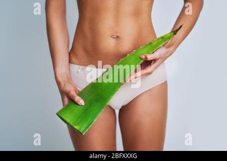 Bella donna adulta in posa naturale con aloe vera foglia Foto Stock