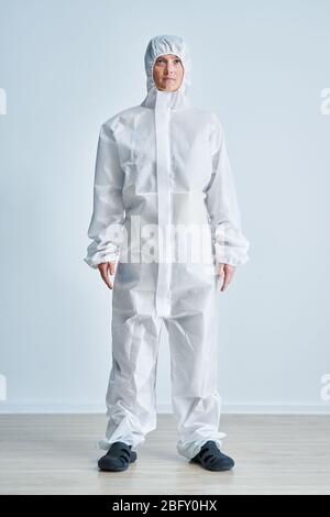 Donna in tuta a rischio biologico su sfondo bianco. Foto Stock