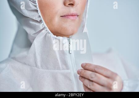 Donna in tuta a rischio biologico su sfondo bianco. Foto Stock