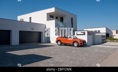 Gyor Hungary 04 07 2020: Casa moderna con tetto piatto. Davanti a lui c'è una vettura Audi Q3. Concetto di business immobiliare. Foto Stock