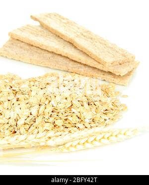 Pile di fiocchi d'avena con spikelets e biscotti d'avena isolati su bianco Foto Stock