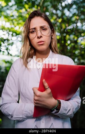 Giovane ingegnere agricolo che lavora in serra. Giovane scienziata femminile che guarda la macchina fotografica Foto Stock