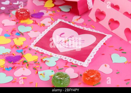 Bella composizione di carta valentine e decorazioni su sfondo rosa primo piano Foto Stock