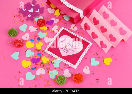 Bella composizione di carta valentine e decorazioni su sfondo rosa primo piano Foto Stock
