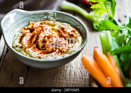 Hummus fatto in casa con verdure fresche per immergerlo Foto Stock