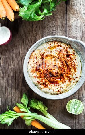 Hummus fatto in casa con verdure fresche per immergerlo Foto Stock