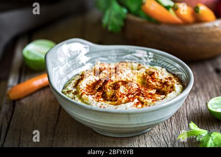 Hummus fatto in casa con verdure fresche per immergerlo Foto Stock