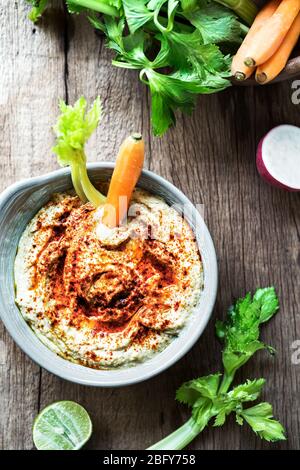 Hummus fatto in casa con verdure fresche per immergerlo Foto Stock