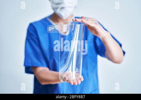 Ritratto di medico femminile che indossa maschera protettiva e visiera protettiva Foto Stock