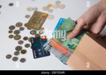 la persona tira i soldi fuori dalla borsa. Tinge, Kazakhstan, banconota. Pacchetto Kraft con valuta cartacea. Valuta nazionale del Kazakistan, KZ. Scambio r Foto Stock