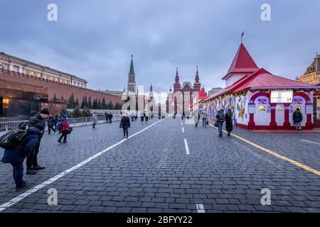 MOSCA, RUSSIA - 11 DICEMBRE 2019: Turisti a piedi vicino alla facciata illuminata del magazzino GUM Department sulla Piazza Rossa. Piazza centrale in un dic nuvoloso Foto Stock