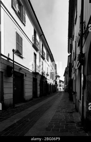 Il silenzio e la desolazione in una città vicino a Milano, domenica mattina, durante Coronavirus. Strada vuota nel centro della città, non c'è gente, i negozi sono clos Foto Stock