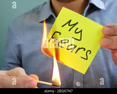 L'uomo brucia i timori. Affrontarli e conquistarli come motivazione. Foto Stock