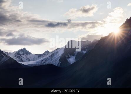 Splendido paesaggio delle montagne innevate con Rising Sun in Kazakistan e in Asia centrale Foto Stock