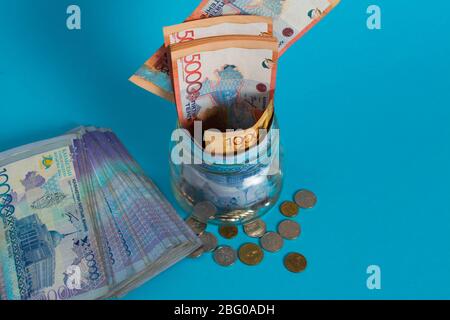 Tinge in un vaso di vetro. Kazakistan, KZ, KZT. Banconote, banconote, monete, Banca. Stipendio, credito, risparmio, paga e spendi. Economia e affari. Foto Stock