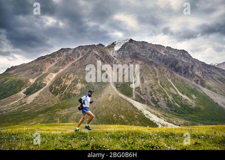 Runner atleta con la barba in esecuzione sul sentiero di montagna Foto Stock