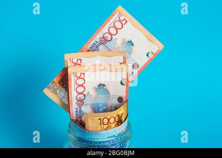Tinge in un vaso di vetro. Kazakistan, KZ, KZT. Banconote, banconote, monete, Banca. Stipendio, credito, risparmio, paga e spendi. Economia e affari. Foto Stock