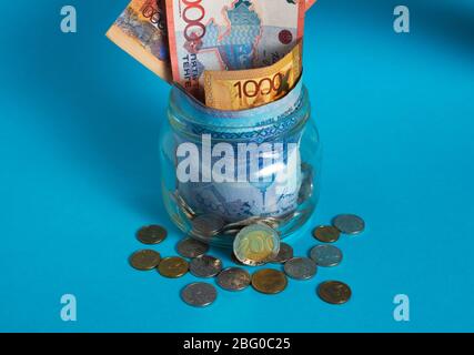 Tinge in un vaso di vetro. Kazakistan, KZ, KZT. Banconote, banconote, monete, Banca. Stipendio, credito, risparmio, paga e spendi. Economia e affari. Foto Stock
