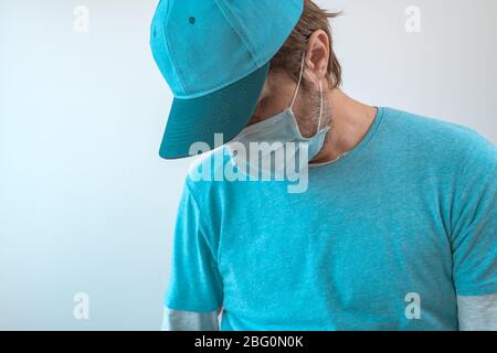 Ragazzo di consegna con maschera protettiva per il viso durante il blocco virus indossare t-shirt blu e cappello da baseball, messa a fuoco selettiva Foto Stock