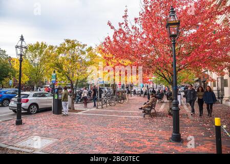 La gente che gode un caldo pomeriggio d'autunno in una piccola piazza di mattoni lungo Pleasant Street nel centro di Portsmouth Foto Stock