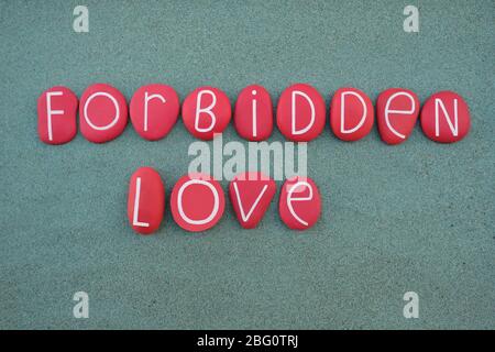 Amore proibito, testo creativo composto da lettere di pietra rossa su sabbia verde Foto Stock