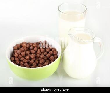 Cereali deliziosi e sani in ciotola con latte isolato su bianco Foto Stock