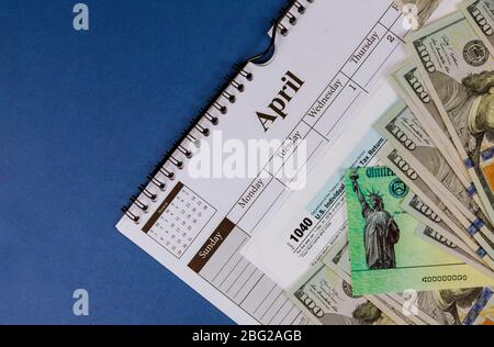 Closeup 1040 forma fiscale con assegno di rimborso e la valuta US dollar banconote Foto Stock