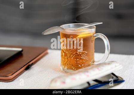 Un bicchiere di tè caldo con limone sul tavolo. Concetto di soggiorno a casa. Foto Stock