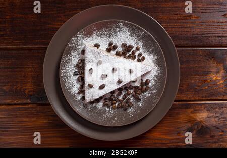 Un pezzo di torta al cioccolato con zucchero e chicchi di caffè. Cibo, dessert, dolce. Biscotto, brownie, tiramisù, cheesecake. Cuoco a casa. Prodotti da forno. Foto Stock