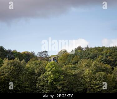 Il centro visitatori tra gli alberi. The Macallan Distillery and Visitor Experience, Aberlour, Regno Unito. Architetto: Rogers Stirk Harbour + parte Foto Stock