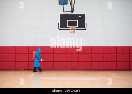 Changsha, provincia cinese Hunan. 20 aprile 2020. Un personale spruzza disinfettante in un campo da baskeball presso un centro sportivo Changsha, provincia Hunan della Cina meridionale, il 20 aprile 2020. Credit: Chen Sihan/Xinhua/Alamy Live News Foto Stock