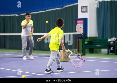 Changsha, provincia cinese Hunan. 20 aprile 2020. Un bambino gioca a tennis con il suo allenatore presso un centro sportivo Changsha, provincia Hunan della Cina meridionale, il 20 aprile 2020. Credit: Chen Sihan/Xinhua/Alamy Live News Foto Stock