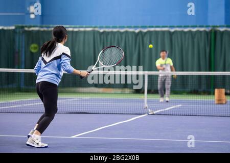 Changsha, provincia cinese Hunan. 20 aprile 2020. Una ragazza gioca a tennis con il suo allenatore presso un centro sportivo Changsha, provincia Hunan della Cina meridionale, il 20 aprile 2020. Credit: Chen Sihan/Xinhua/Alamy Live News Foto Stock