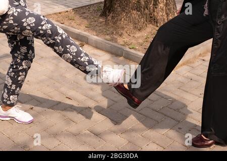 Saluto alternativo con le gambe durante l'epidemia di infezione da coronavirus causata dal virus Covid-19. Mantenere la distanza sociale tra frie Foto Stock