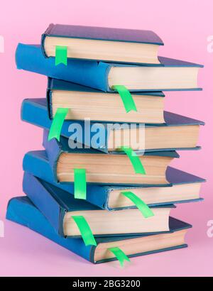 Molti libri con segnalibri su sfondo rosa Foto Stock