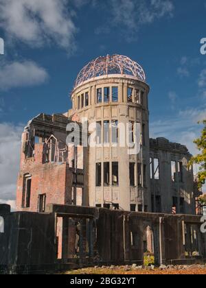 Contro un cielo blu con nuvole di luce, il Gennaku Dome / Atomic Bomb Dome al Parco Memoriale della Pace di Hiroshima, Giappone Foto Stock