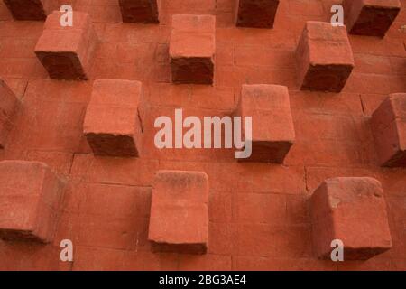 Mattoni arancioni astratti con struttura cubica che si apre dal muro Foto Stock