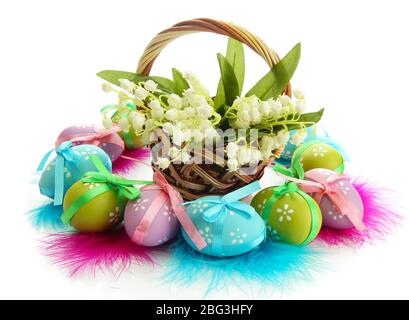 Belle uova di pasqua e gigli della valle in cesto, isolato su bianco Foto Stock